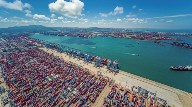 山東港口青島港前灣港區，大型集裝箱貨輪正在繁忙地進行靠離泊作業。